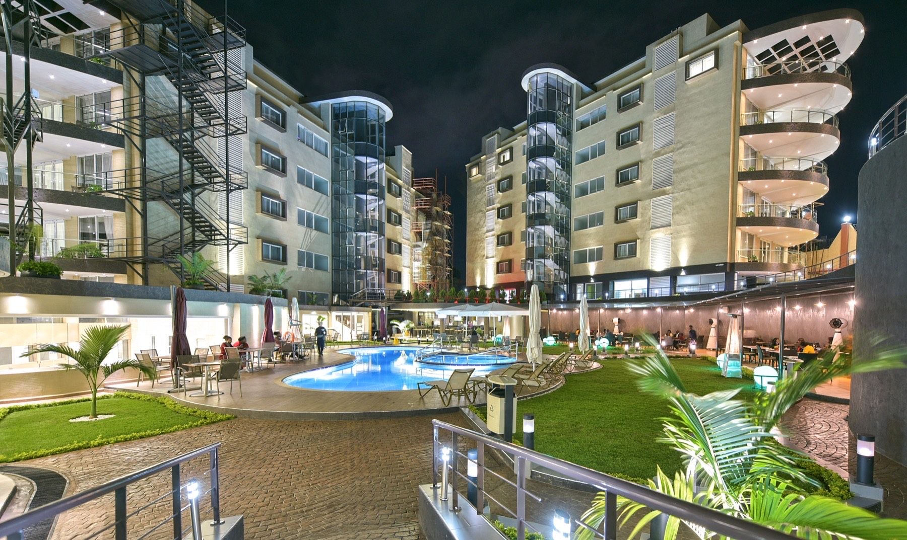 Aerial night view of Skyz Hotel Kampala glowing above the lights of Naguru and the city