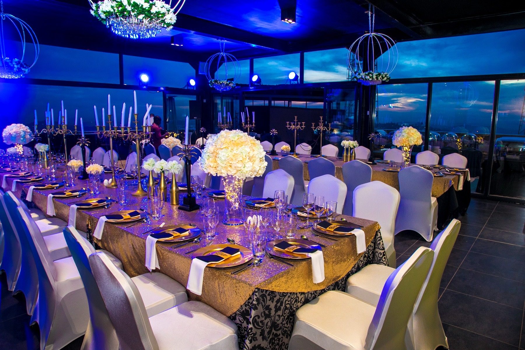 Banquet hall dressed for a wedding with chandeliers and draped chairs