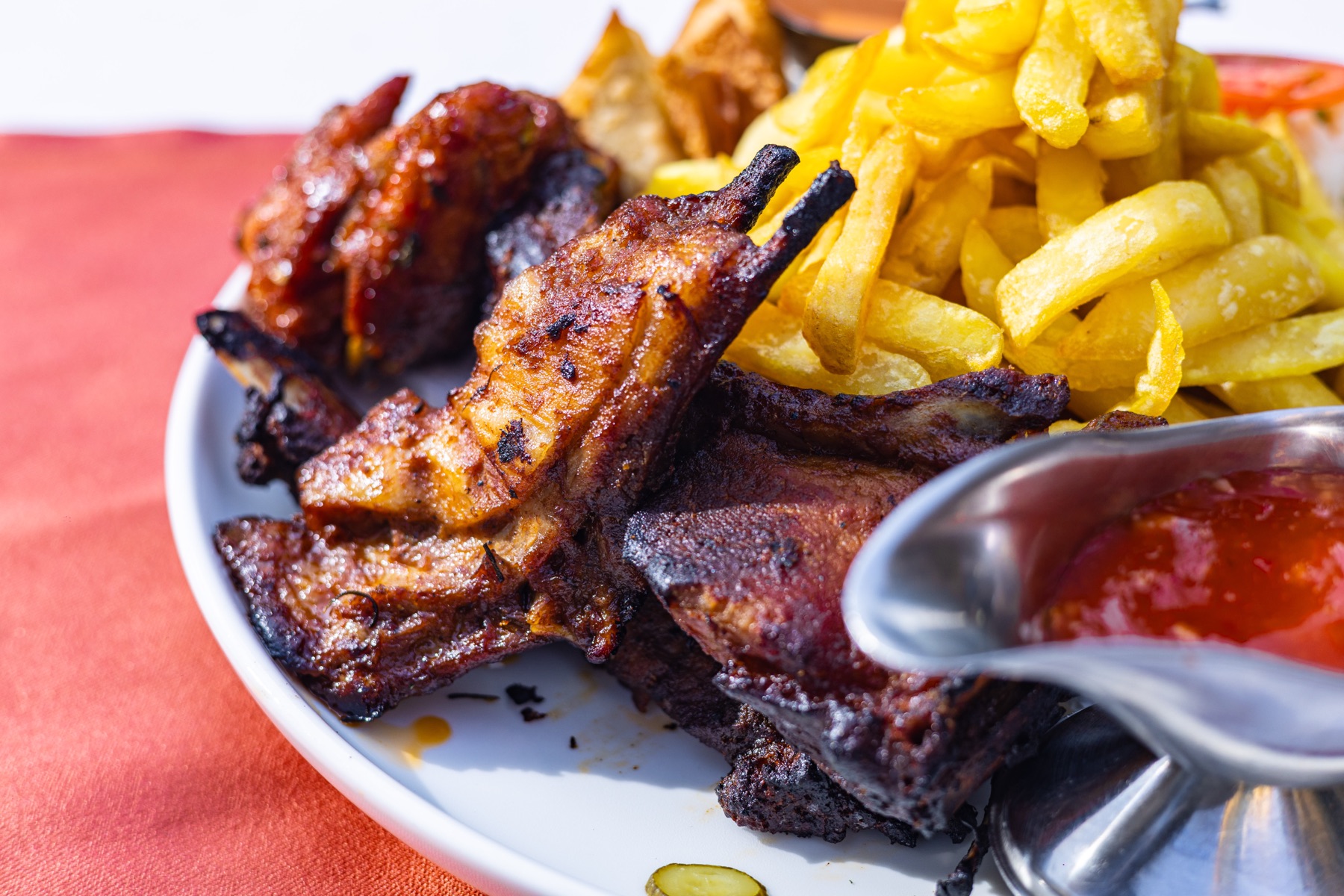 Smoky grilled pork ribs with fries and BBQ sauce at Tropicanna Poolside