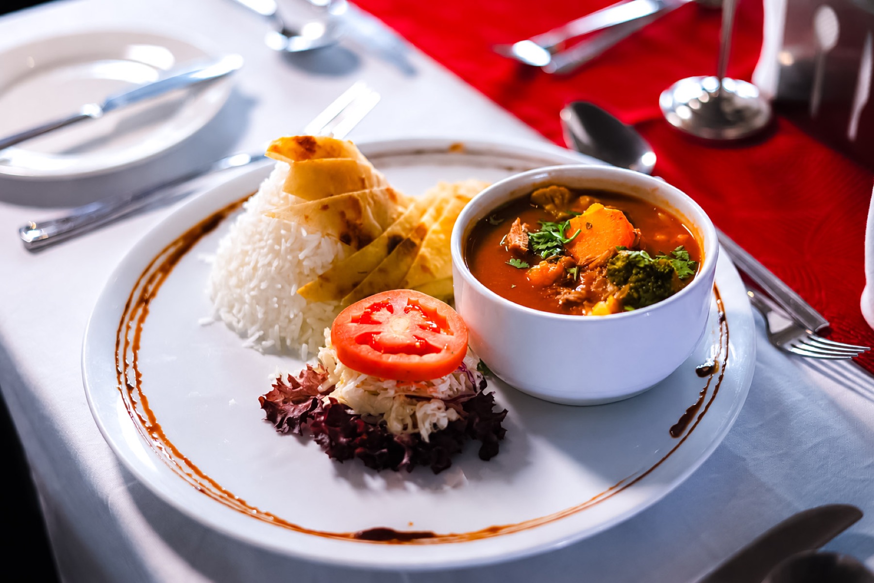 A plated Chapter Two dinner of rice, chapati and a meat and vegetable stew