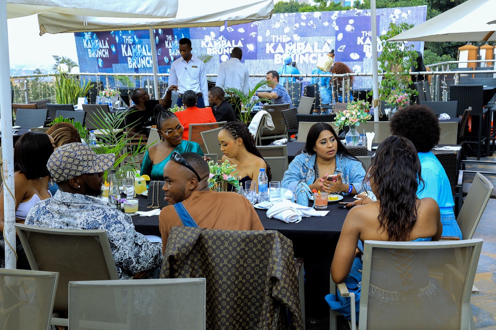 Guests dine on the terrace beside the denim-themed backdrop at The Kampala Style Brunch, July 2024