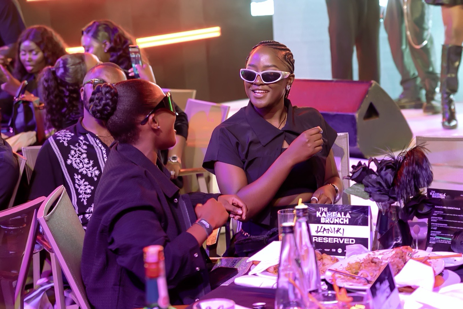 Guests share a laugh beside the reserved table sign at The Kampala Style Brunch, October 2024