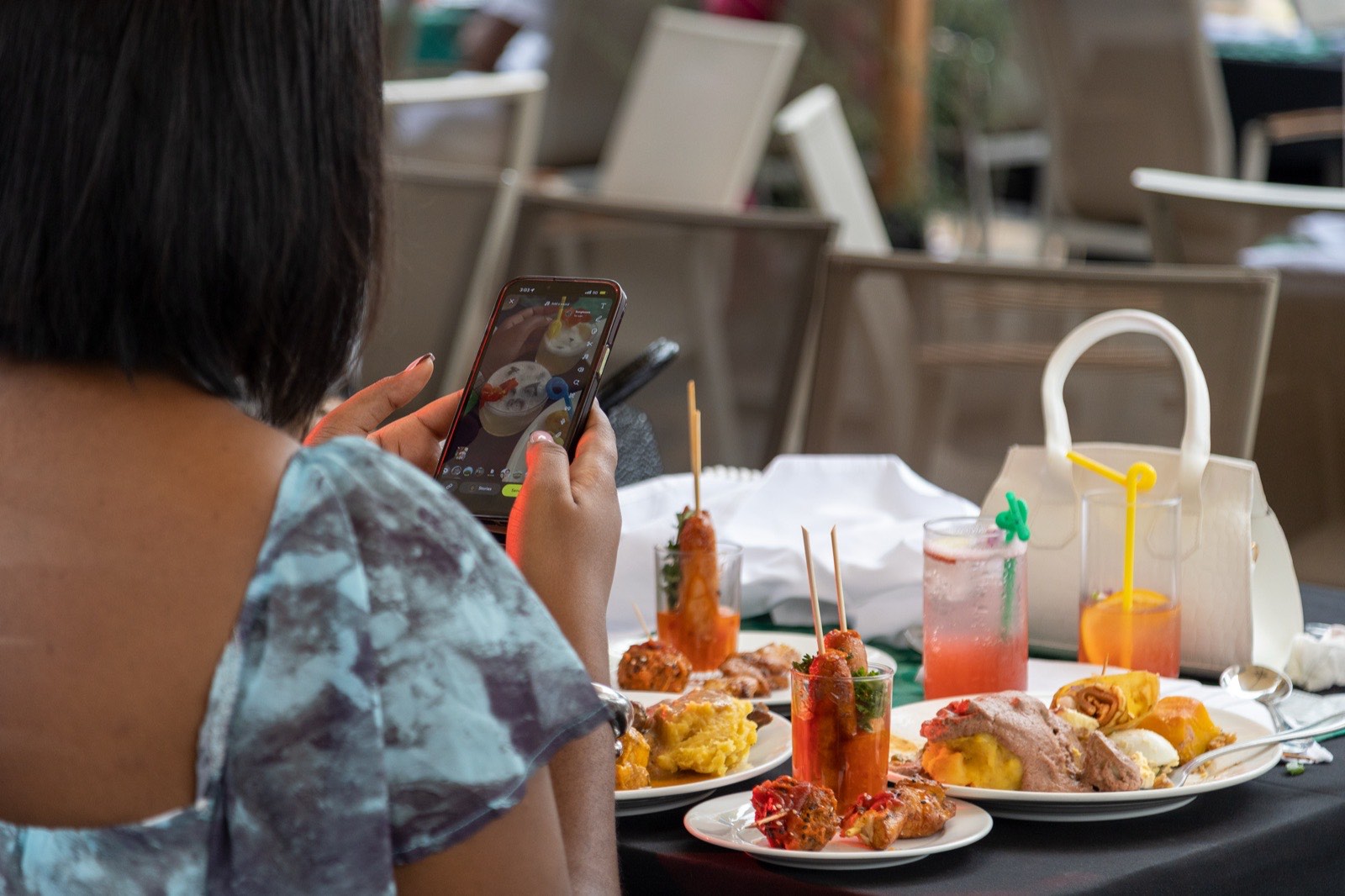 A guest photographs her food at the table during The Kampala Style Brunch, September 2024