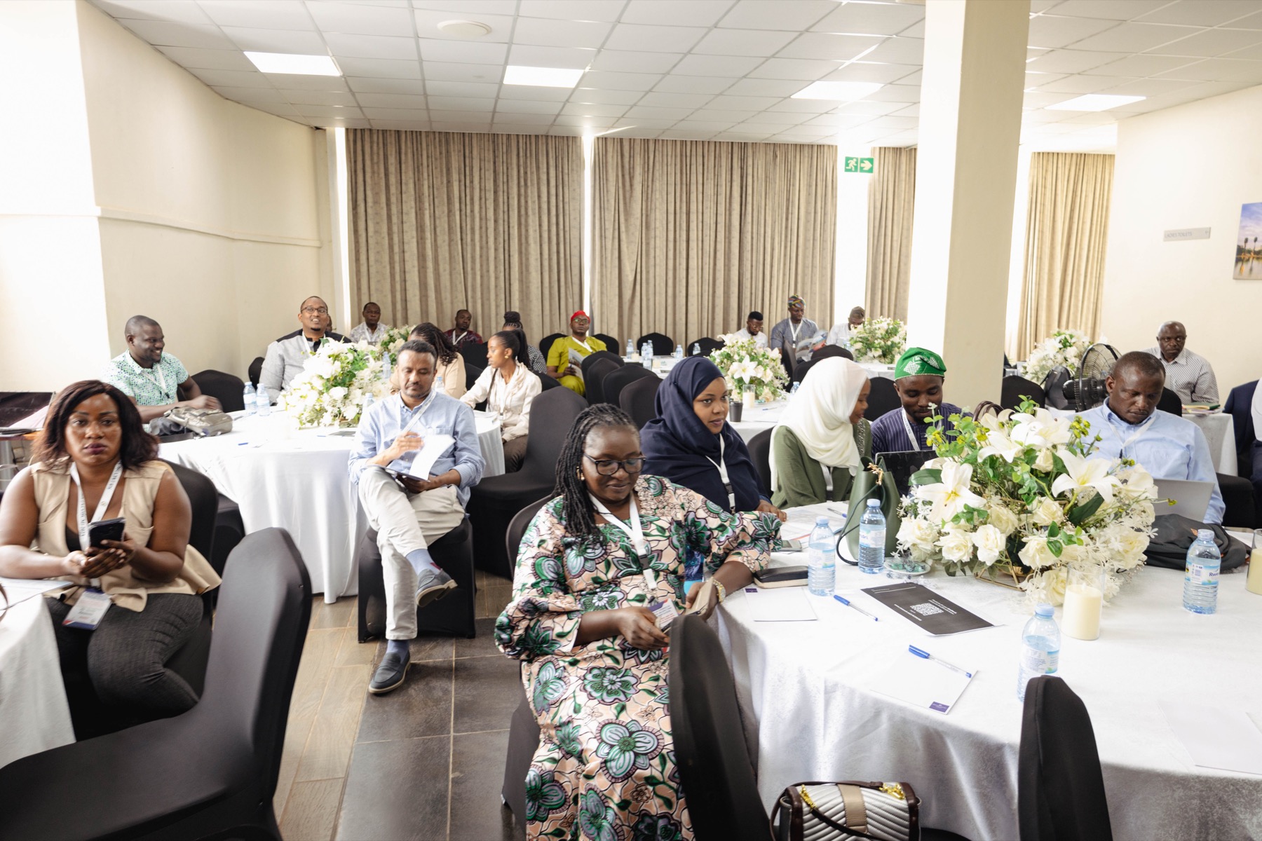 Delegates seated at round tables in Nairobi Hall during a conference