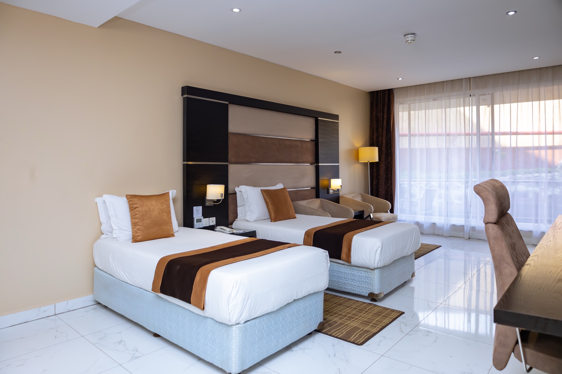 Twin Suite with two twin beds and a separate sitting area at Skyz Hotel Kampala